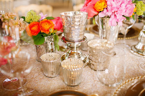 Vintage inspired silver table decor flanked by bright pink and coral flowers - photo by Dan Stewart Photography